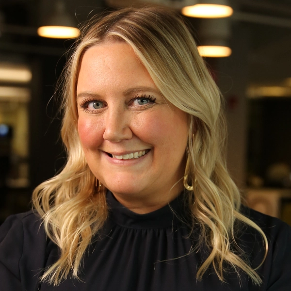 Smiling White woman with long blonde hair and black blouse