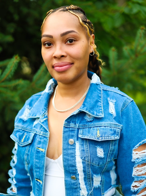 Young smiling Black woman with blonde braid accents wearing a jean jacket